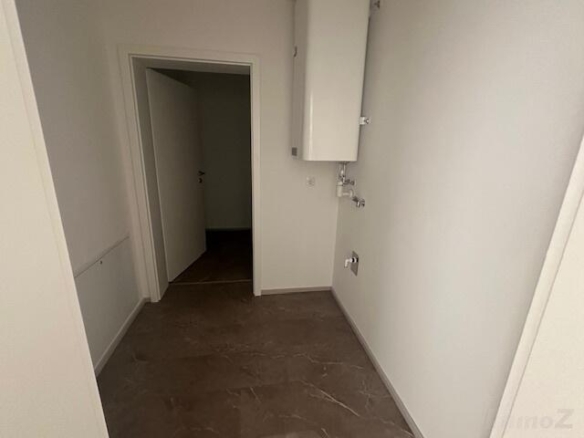 Waschmaschinenraum mit dahinterliegenden Abstellraum