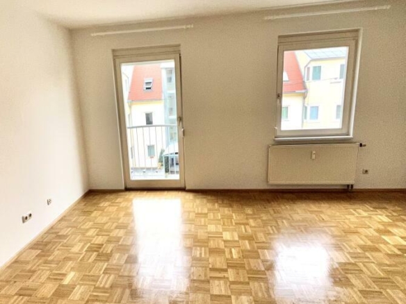 Wohnraum mit offener Küche und Ausgang auf den Balkon